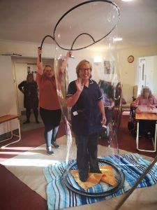 Nursing home activity. Carehome assisted therapy sensory bubble session nurse in a bubble.