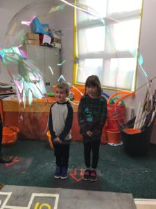 KIB string wand, putting kids inside big bubbles.