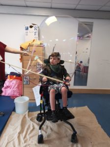 Kid inside a bubble wand kit.