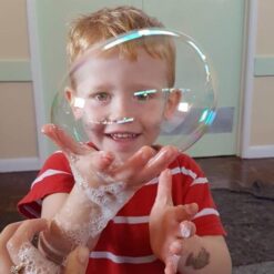 boy holding bubble blowing with hands