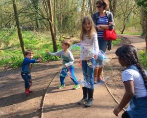 Kids blowing bubbles inside bubbles as a bubble activity for kids.