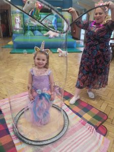 Children's bubble entertainer putting holly inside a bubble