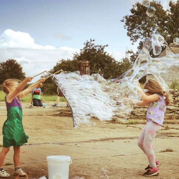 sophie and holly playing with a giant bubble net wand