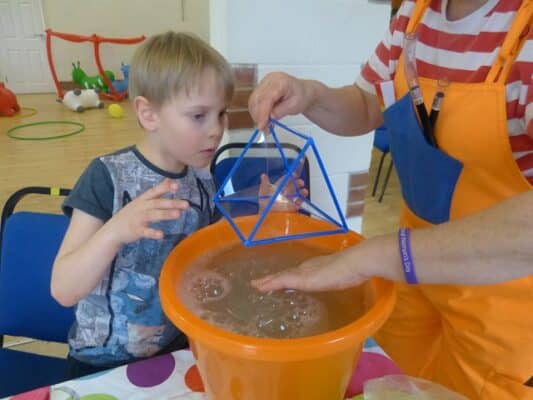 School workshops. Triangular prism bubble shape activity for STEM science and maths lesson in school.