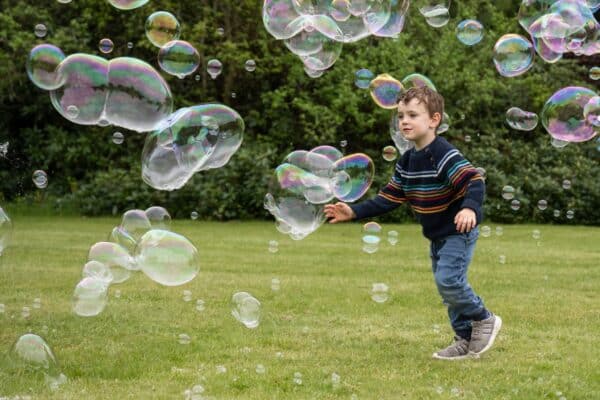 child chasing bubbles at a bubble party. special needs birthday party.