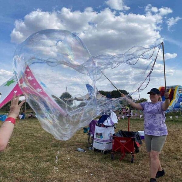 Bubble entertainer making giant bubbles with a multi loop string wand.