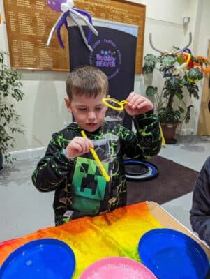 kid making bubble caterpiller party workshop at a bubble science birthday party.
