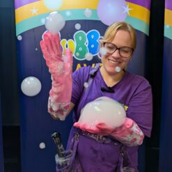 Bubble entertainer holding and playing with a fog smoke filled bubble