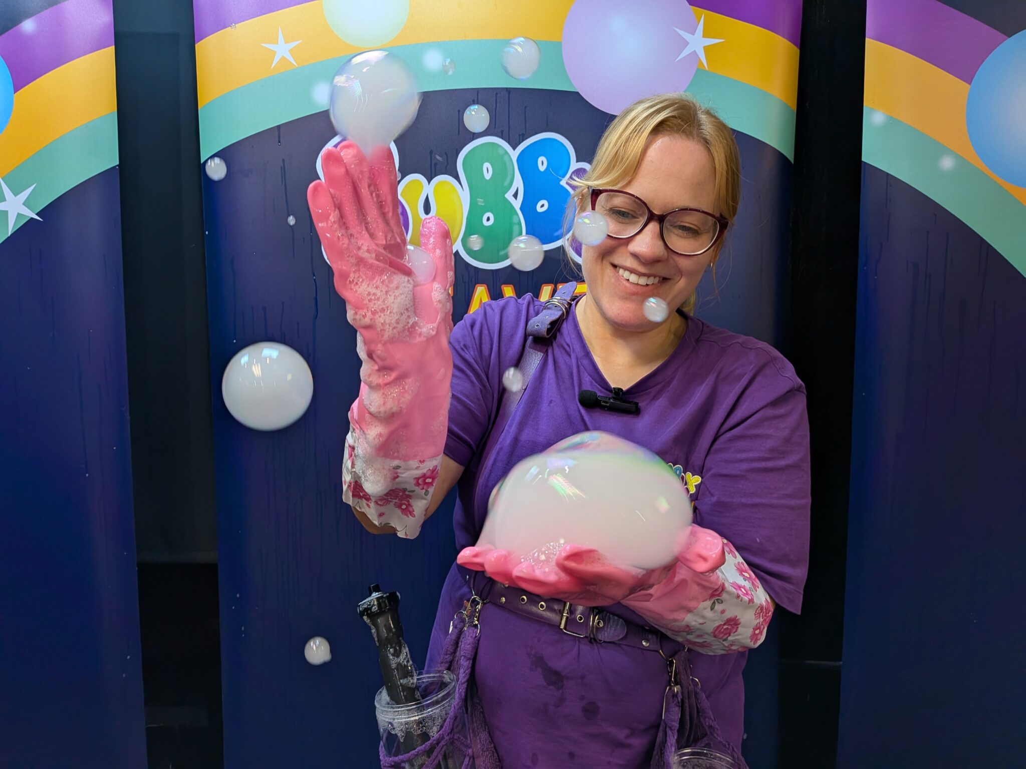 Bubble entertainer holding and playing with a fog smoke filled bubble