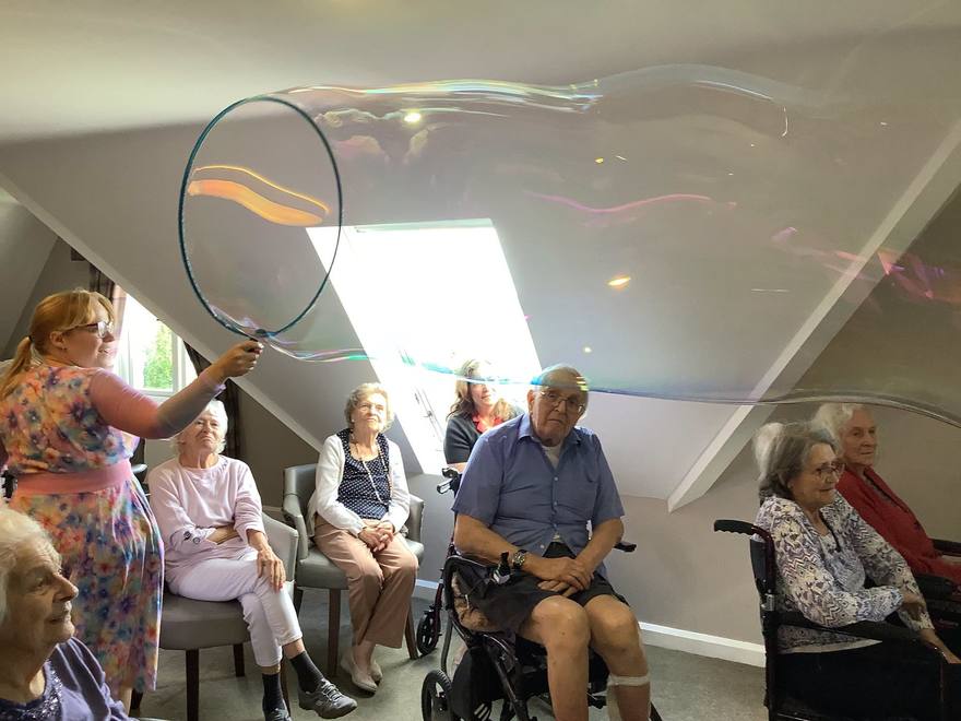 A giant bubble stretching the width of a care home lounge above seated residents